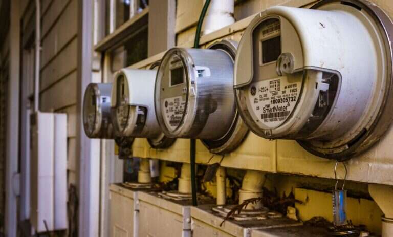 Smart electricity meters on the outside wall of a home, the kind of device that shares the 902 to 928 MHz band with amateur radio