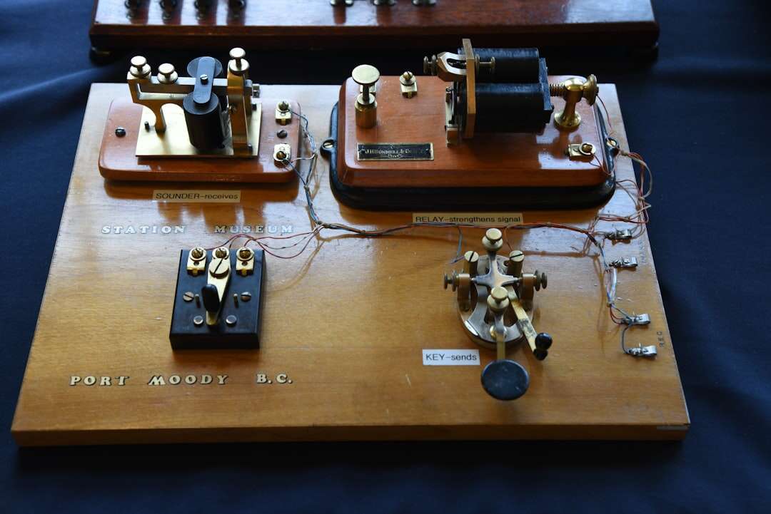 An antique telegraph key mounted on a wooden board, the instrument that sent the dots and dashes of Morse code